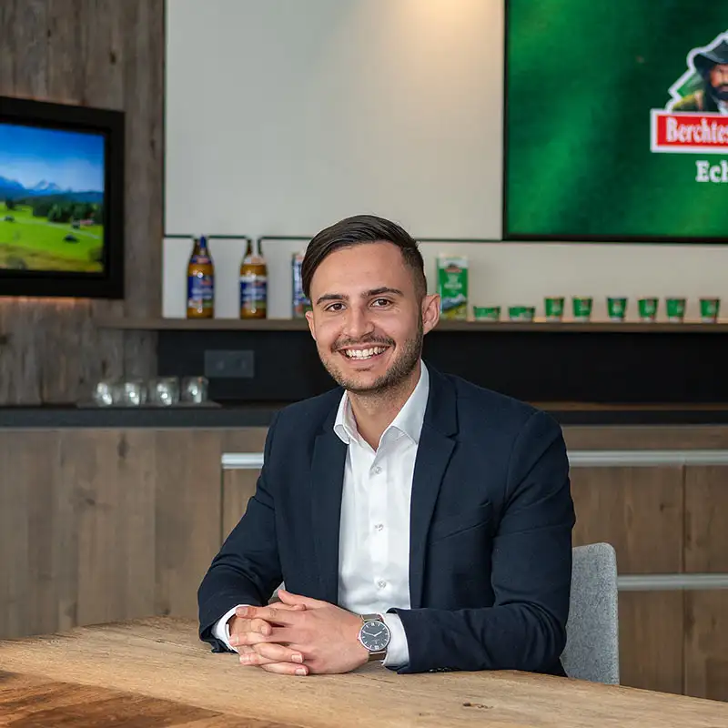 Portrait Dominik Stockhammers vom Berchtesgadener Lands, er sitzt lächelnd im Büro Portrait Dominik Stockhammers vom Berchtesgadener Lands, er sitzt lächelnd im Büro