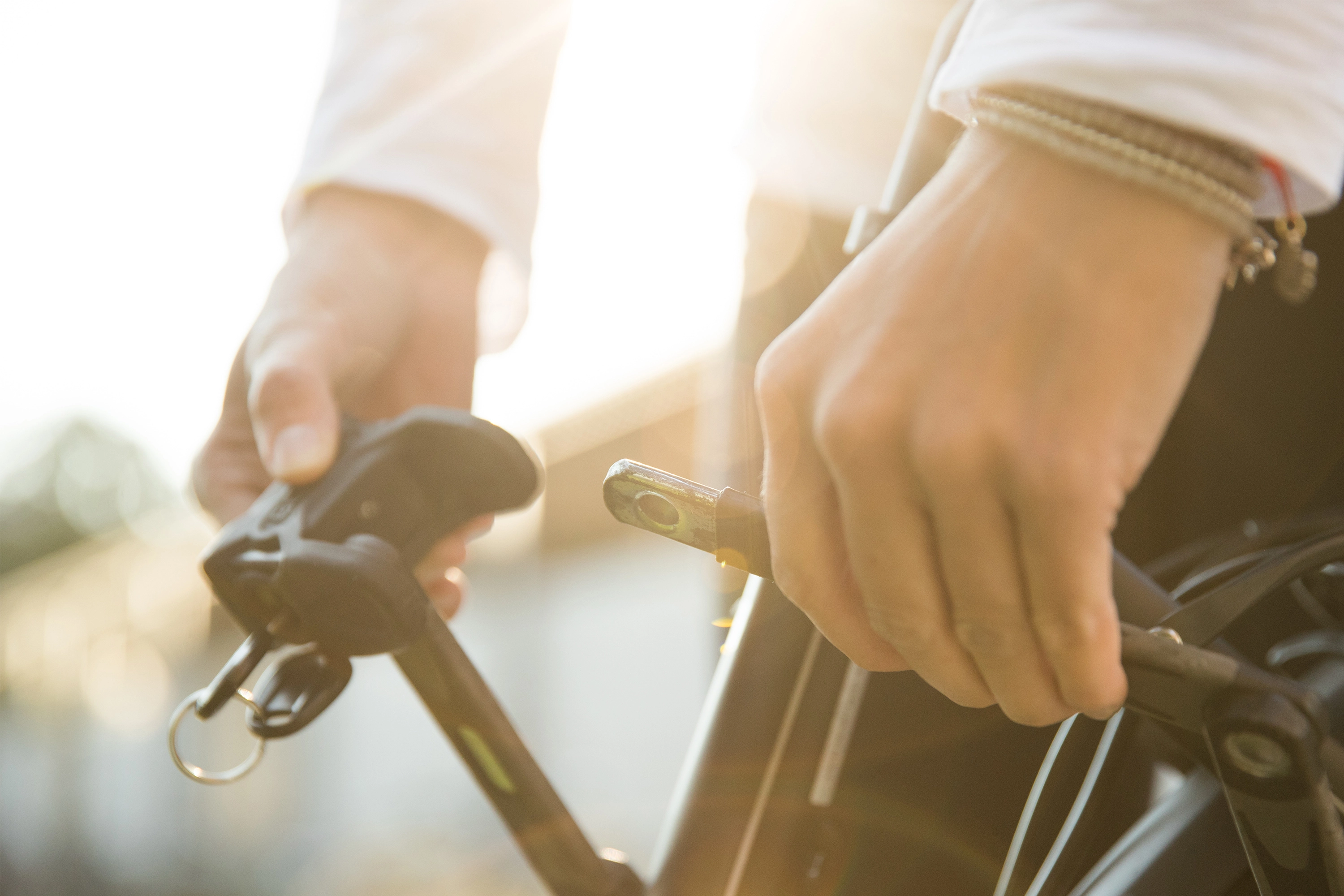 Eine Detailaufnahme eines Radfahrers, der sein Fahrradschloss schließt